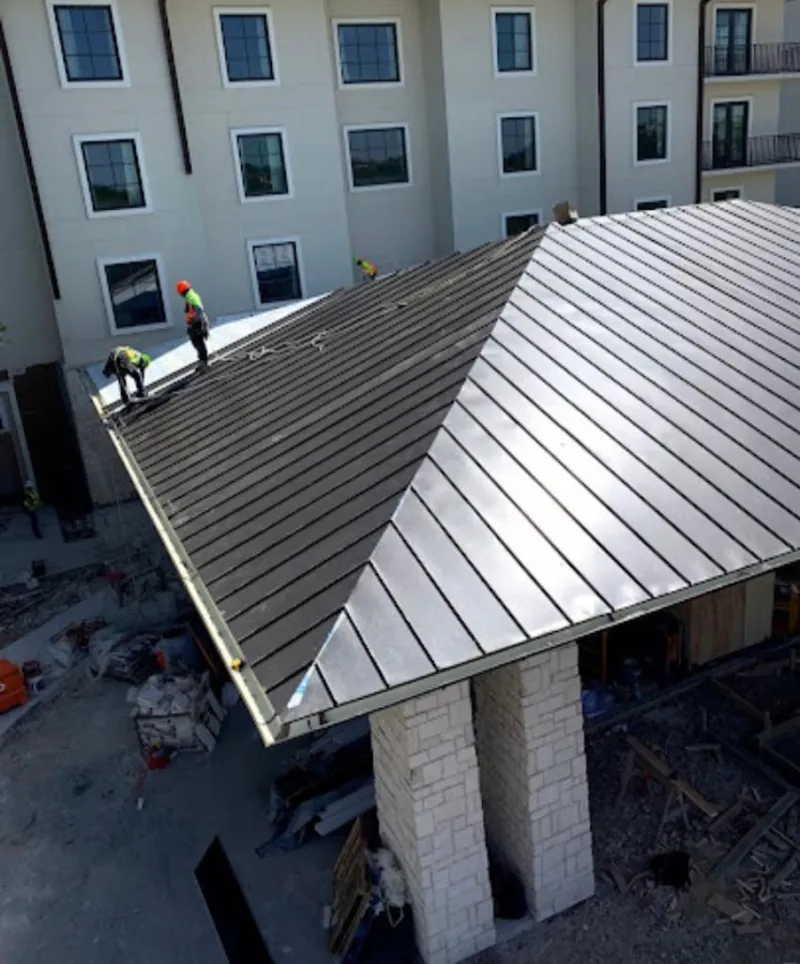 Crew installing standing seam metal roof panels on a commercial project in Santa Clara